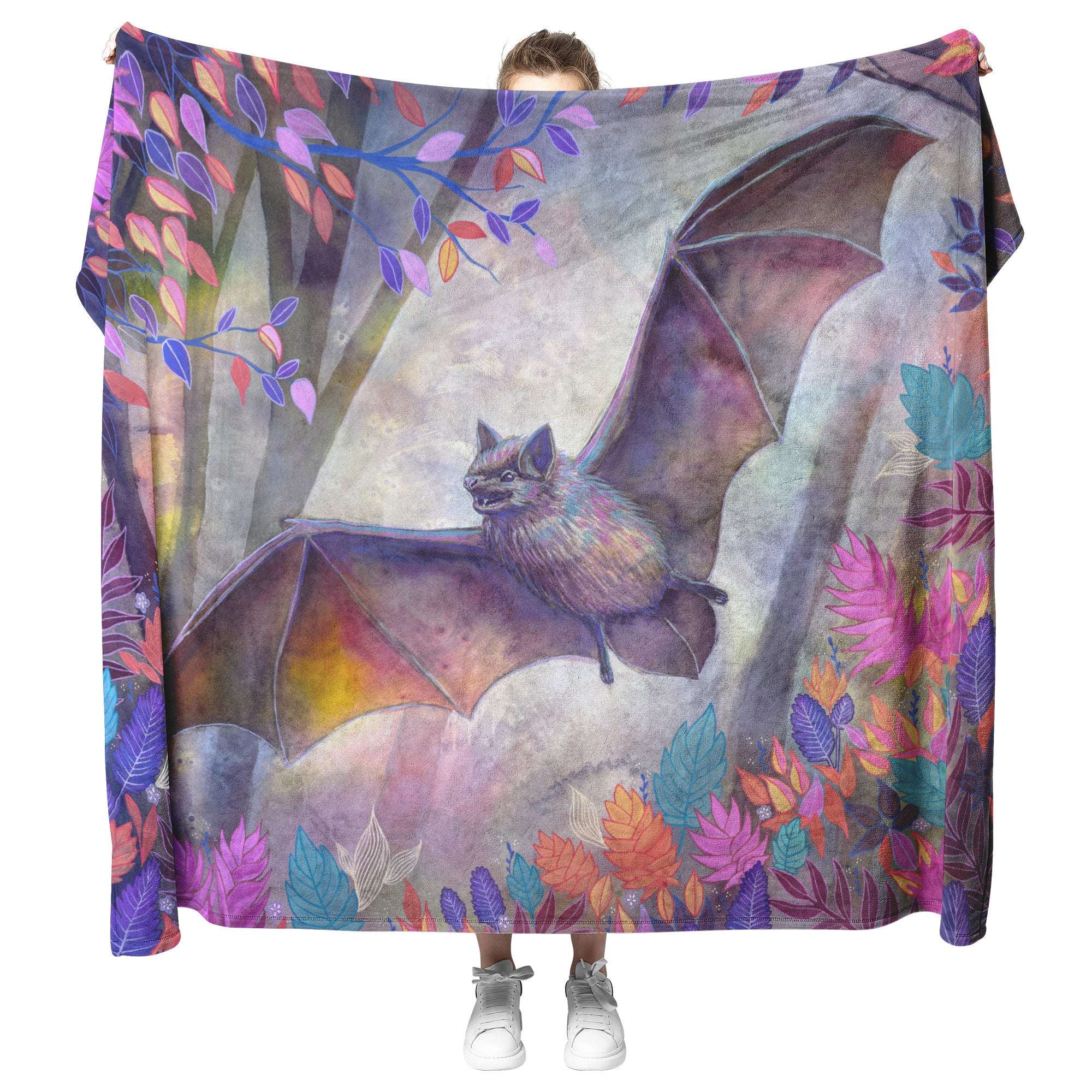 Person holding up a Bat Blanket in front of themselves, featuring a colorful illustration of a bat with wings spread, surrounded by vibrant foliage.