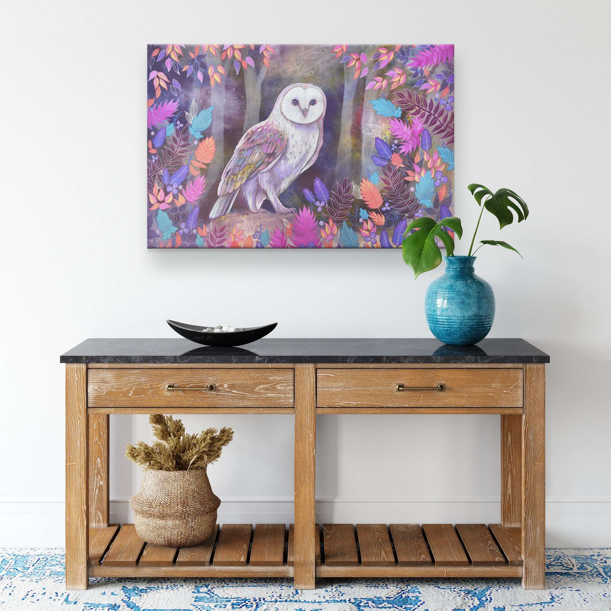 A colorful Canvas Owl Art Print of a barn owl on a wall above a wooden table.