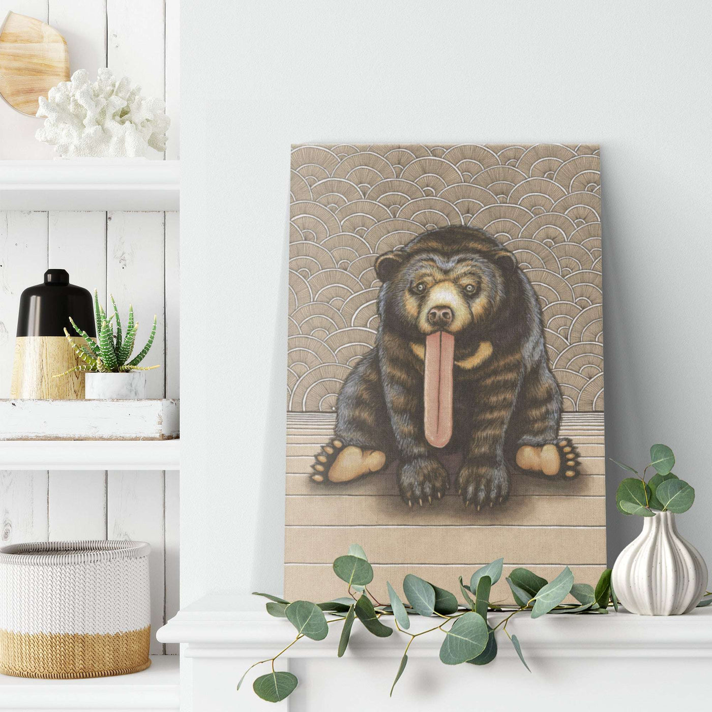 Art print of a Canvas Sun Bear Print with exaggerated features, positioned on a shelf amidst decorative items in a stylish room.