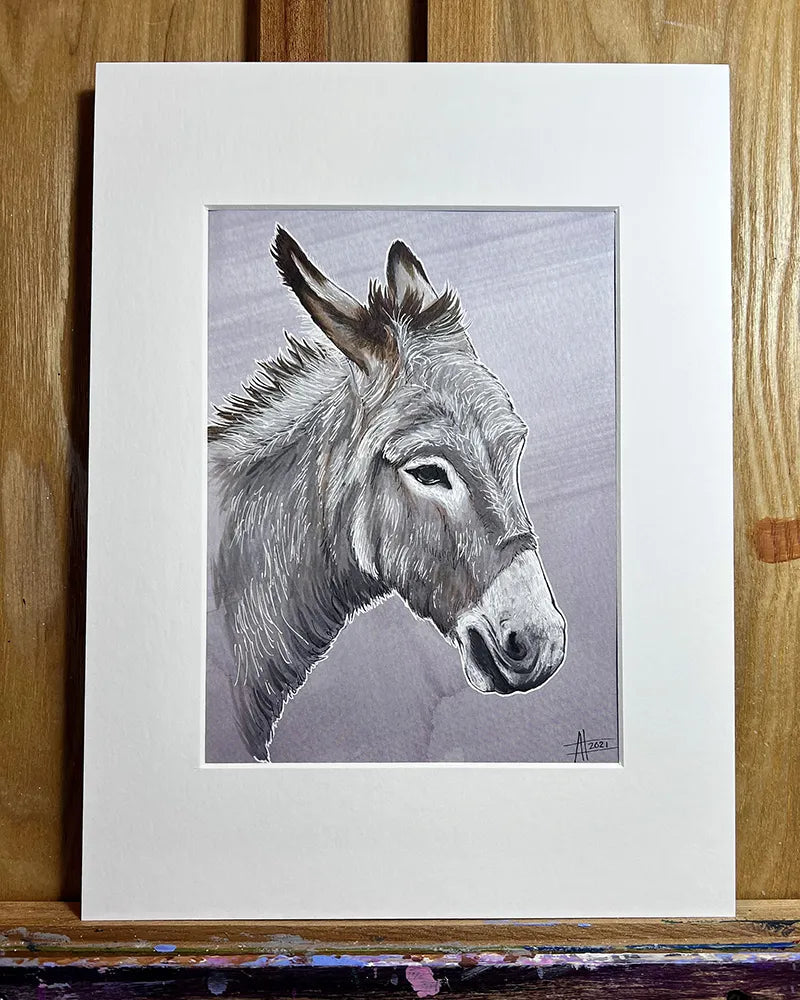 Detailed marker and pen portrait of a donkey, framed with a white mat, leaning against a wooden backdrop.