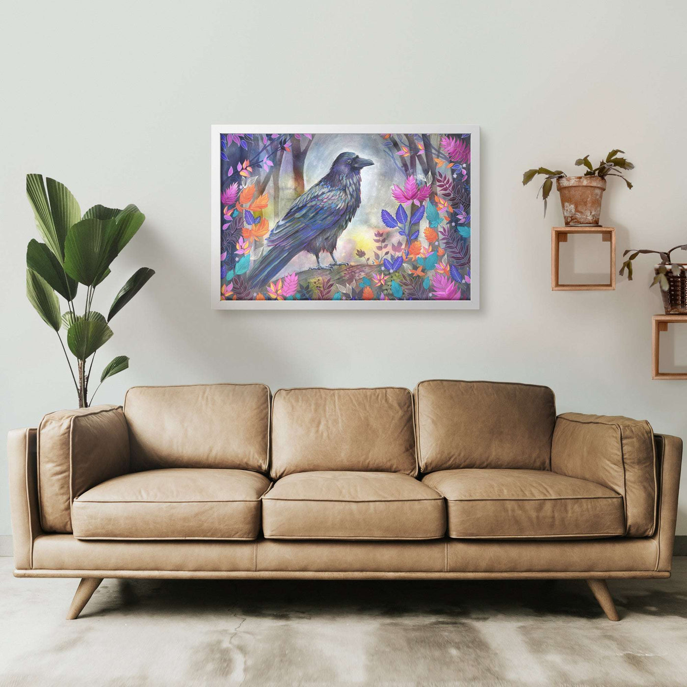 A modern living room wall, decorated with a colorful Framed Raven Art Print surrounded by vibrant flowers.