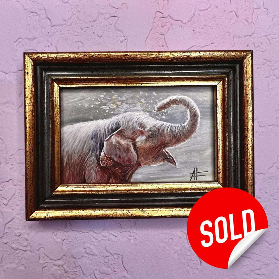 Miniature portrait of an elephant with trunk curled, framed in gold, marked sold on a purple wall.