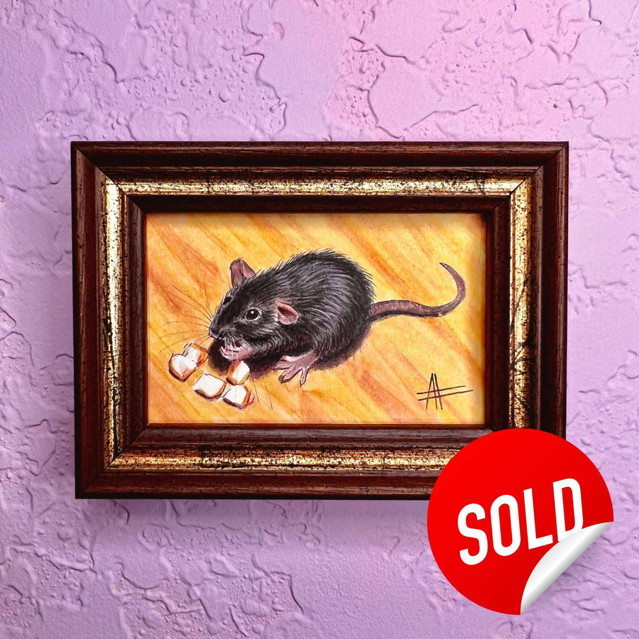 Framed mini painting of a black rat holding corn kernels, marked sold on a purple wall.