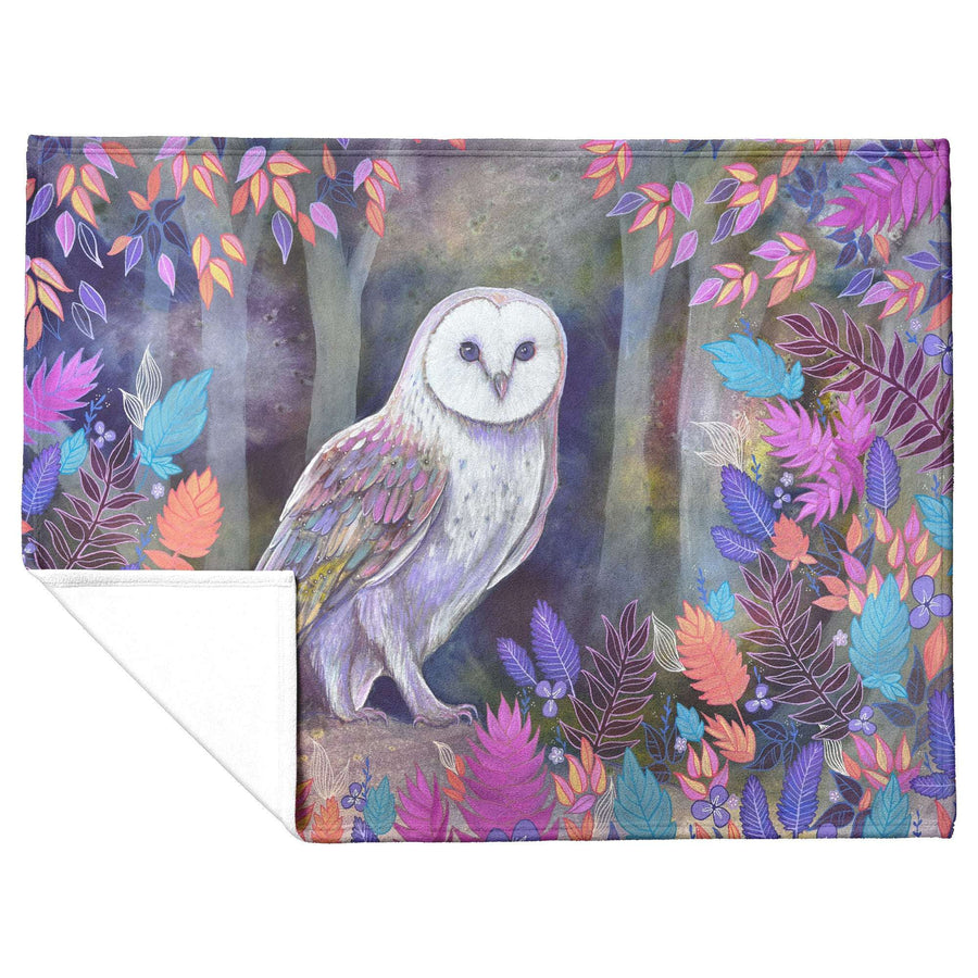Colorful illustrated Owl Blanket featuring a white owl amidst vibrant, multicolored foliage on a purple background.