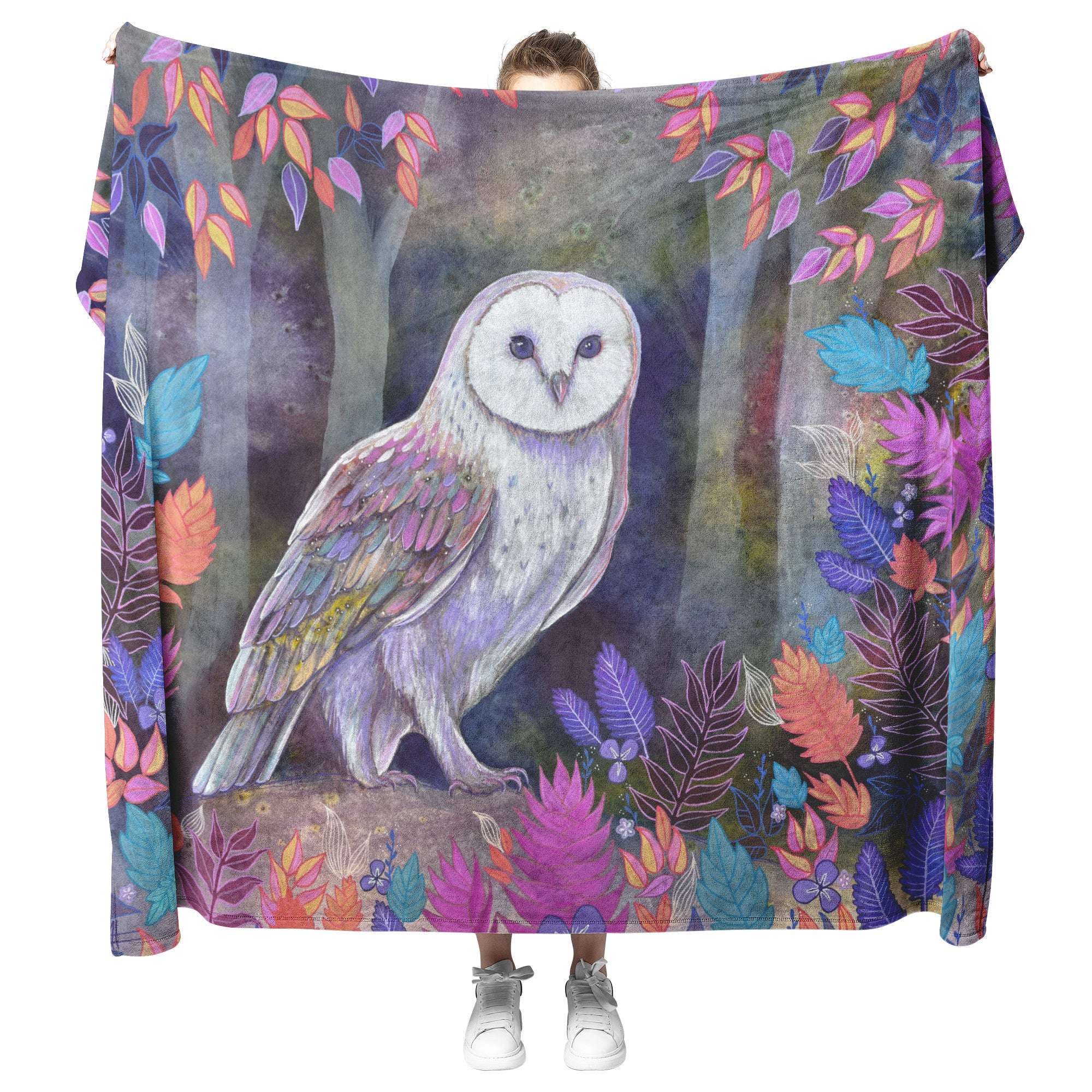 A person holding up an Owl Blanket, showcasing it's size and vibrant illustration.