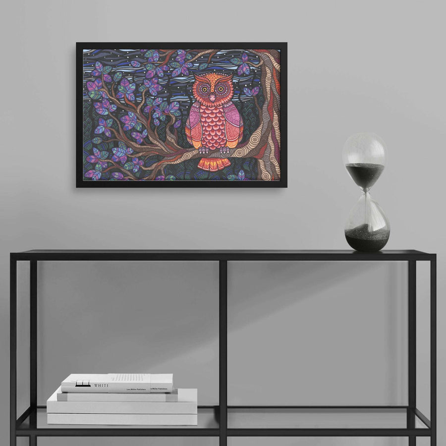 Colorful Framed Owl Tree Framed Print hanging above a minimalist shelf with books and an hourglass.