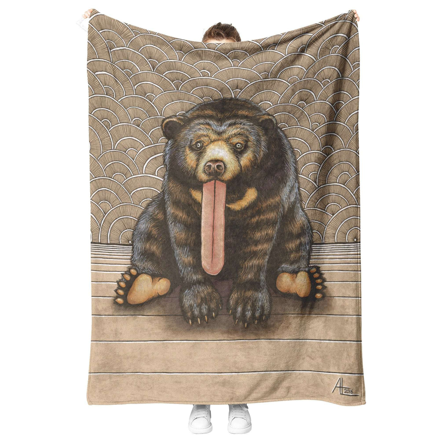 Person holding up a Sun Bear Blanket with a detailed illustration of a bear sitting, its tongue hanging out, in front of a wave-patterned background.