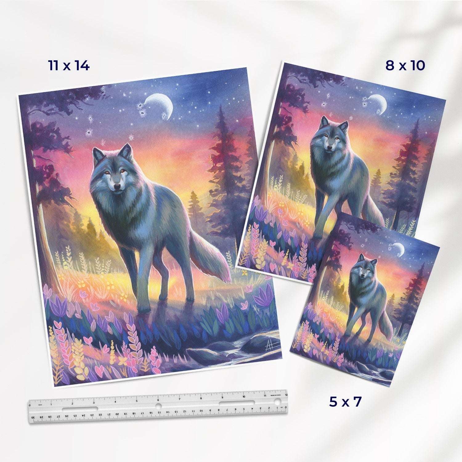 Three different sizes of a Twilight Watch - Fine Art Print Bundle depicting a wolf standing in a vibrant, colorful forest under a crescent moon. a ruler is shown for scale.