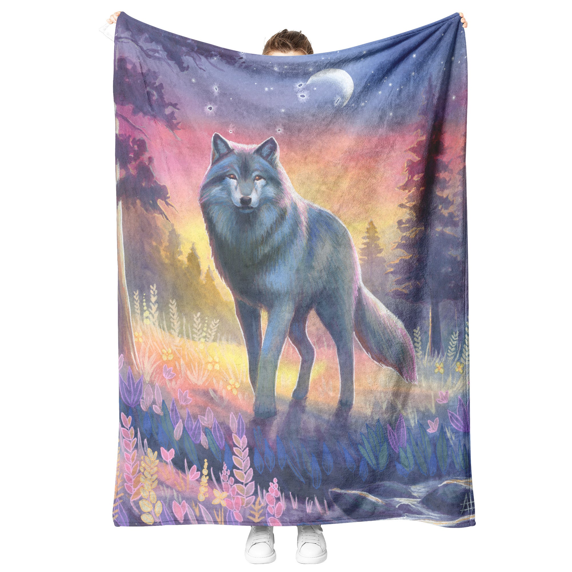 A person holds a Wolf Blanket featuring a vivid illustration of a wolf in a colorful forest under a twilight sky with a crescent moon.