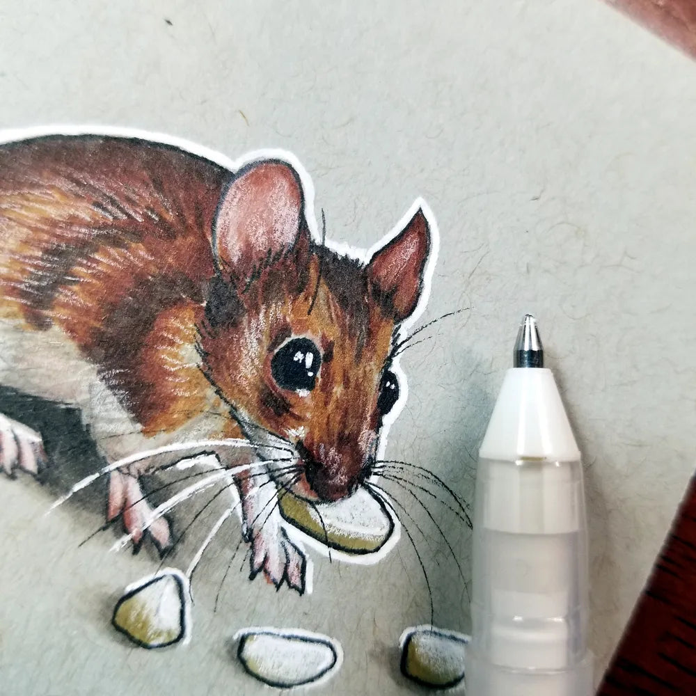 Close-up of a pen and marker drawing of a tiny mouse, it is shown next to a pen tip, highlighting the small size of the art piece.