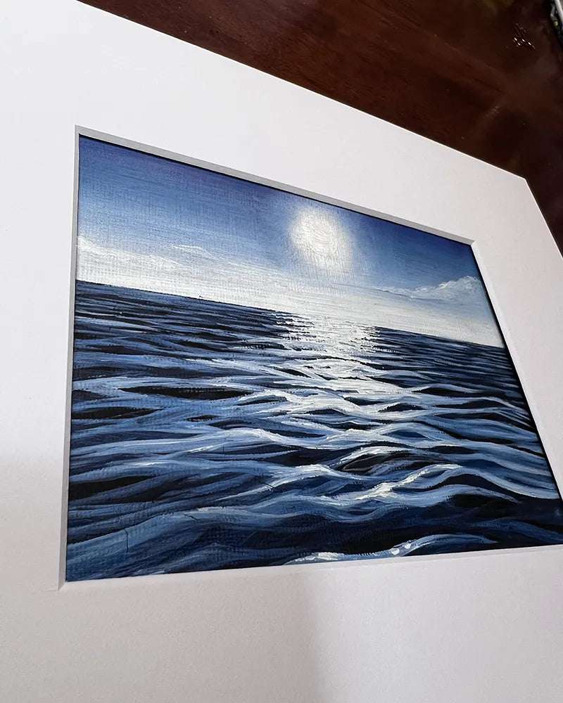 A framed Tiny Seascape - Original Oil Painting by Amanda Lanford of a serene blue ocean with textured waves under a pale sky, displayed on a wooden easel