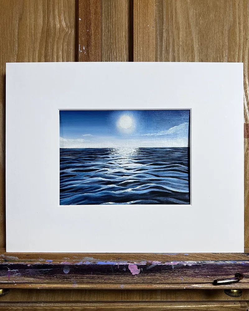 A Tiny Seascape - Original Oil Painting by Amanda Lanford, depicting the ocean under a moonlit sky, framed in a simple white border on a wooden easel.