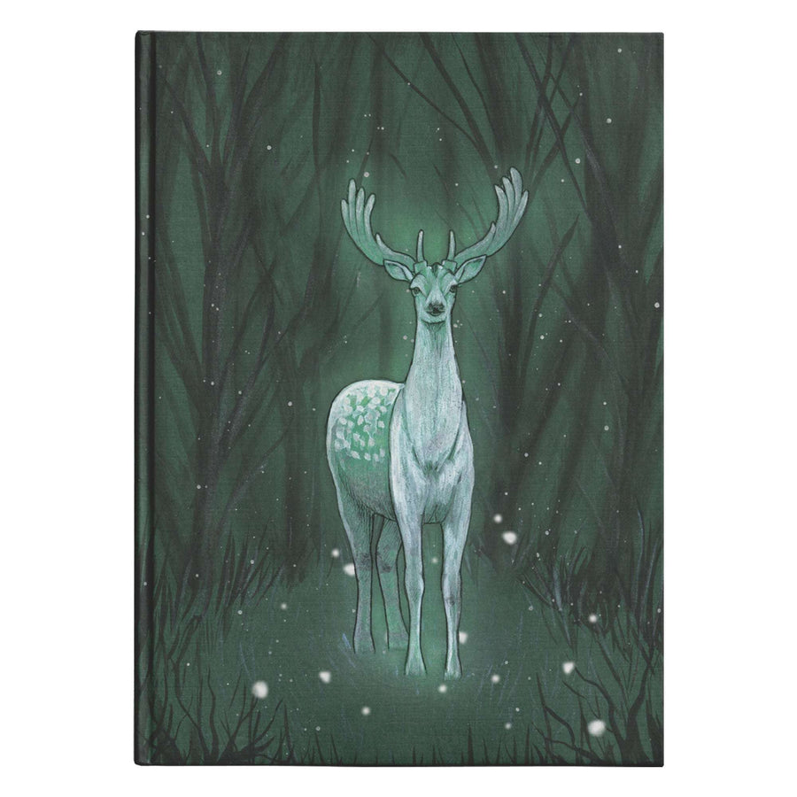 Enchanted Deer Journal with a deer spirit on the cover standing in a dark green forest under gently falling snow.