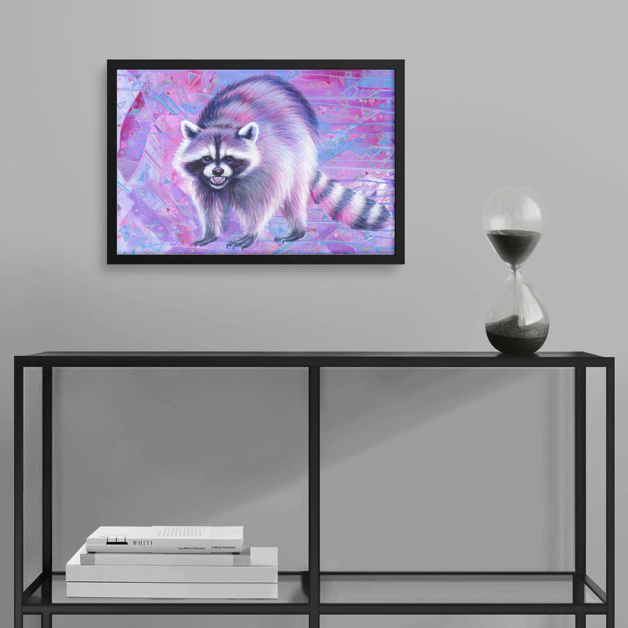 Framed Raccoon Art Print of a raccoon on a pink and blue background, displayed above a modern shelf with books and an hourglass.