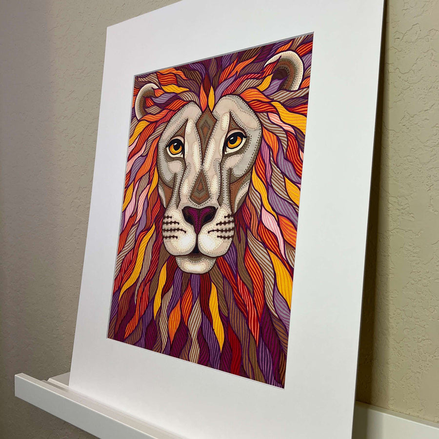 Angled view of a colorful zentangle patterned lion portrait art piece in a white mat.