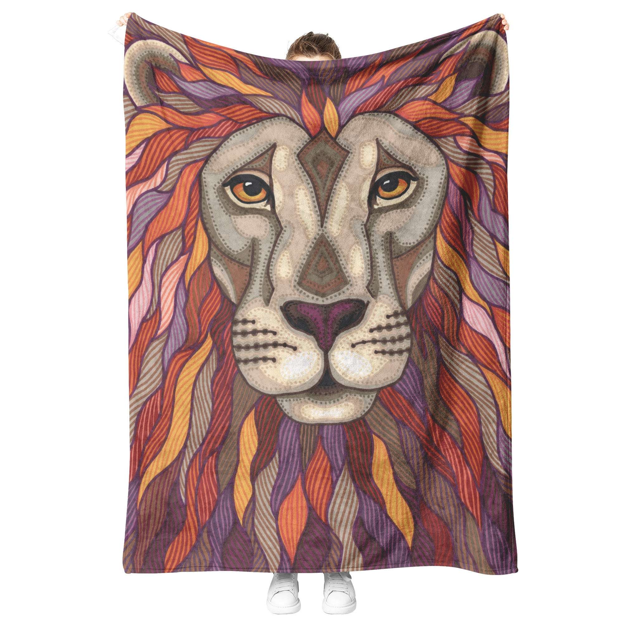 A person standing behind a Lion Pride Blanket featuring a detailed illustration of a lion's face with geometric and organic patterns.
