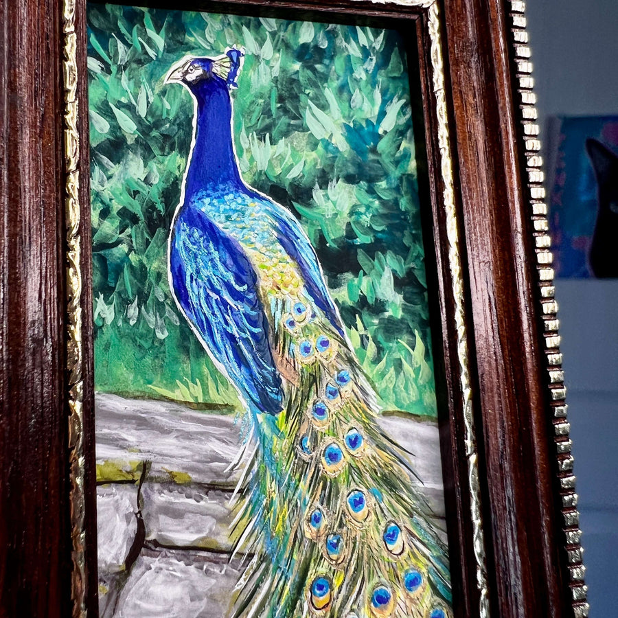 Close-up on a peacock painting emphasizing the vivid blues and greens of its feathers.