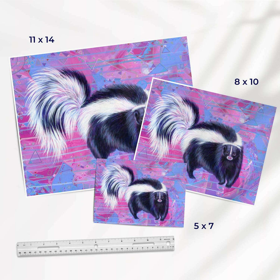 Three "The Skunk (Trash Animals)" fine art prints on a vibrant, abstract pink and blue background in varying sizes: 11x14, 8x10, and 5x7 inches, displayed with a ruler for scale.
