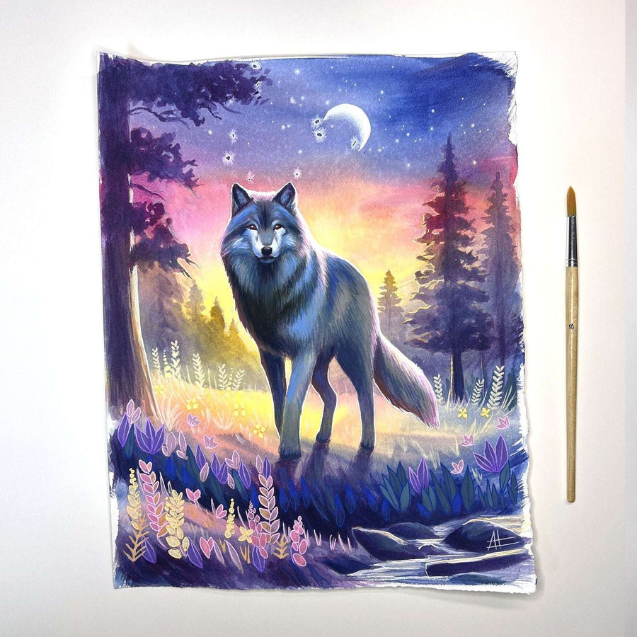 Fine art print of a wolf standing by a riverbank at twilight, with a colorful sunset and crescent moon, accompanied by a paintbrush to the side.