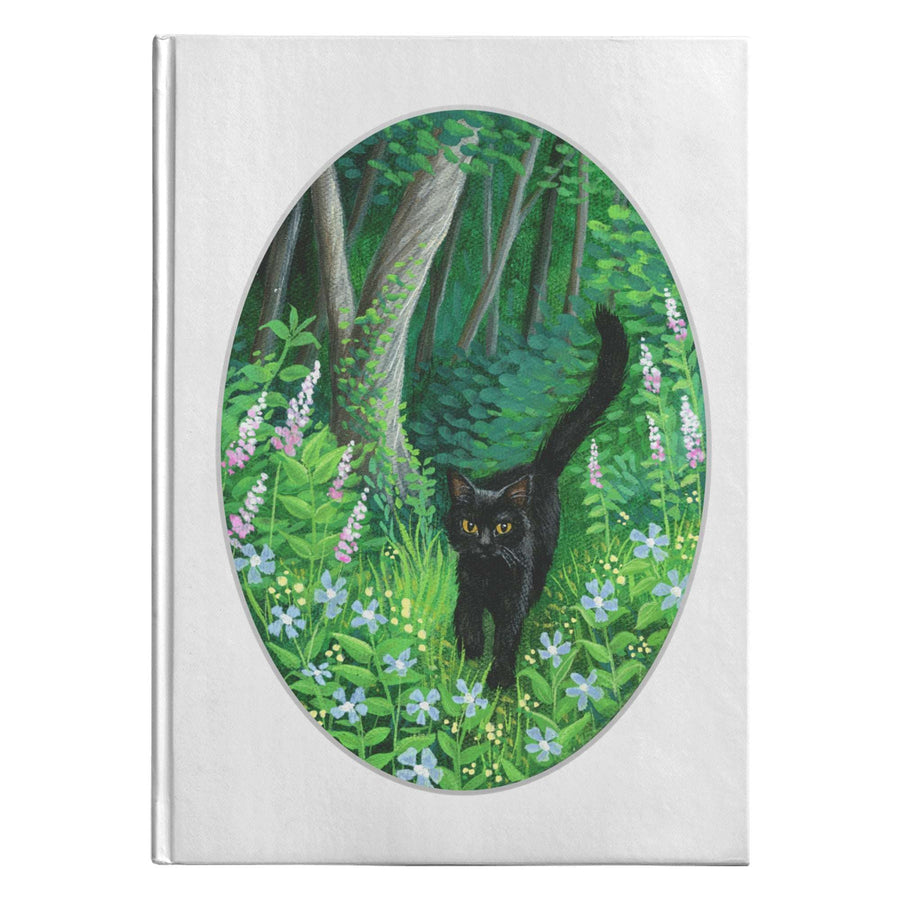 Whiskered Welcome Journal featuring an illustration of a black cat in a lush green forest with purple flowers, framed in an oval shape.