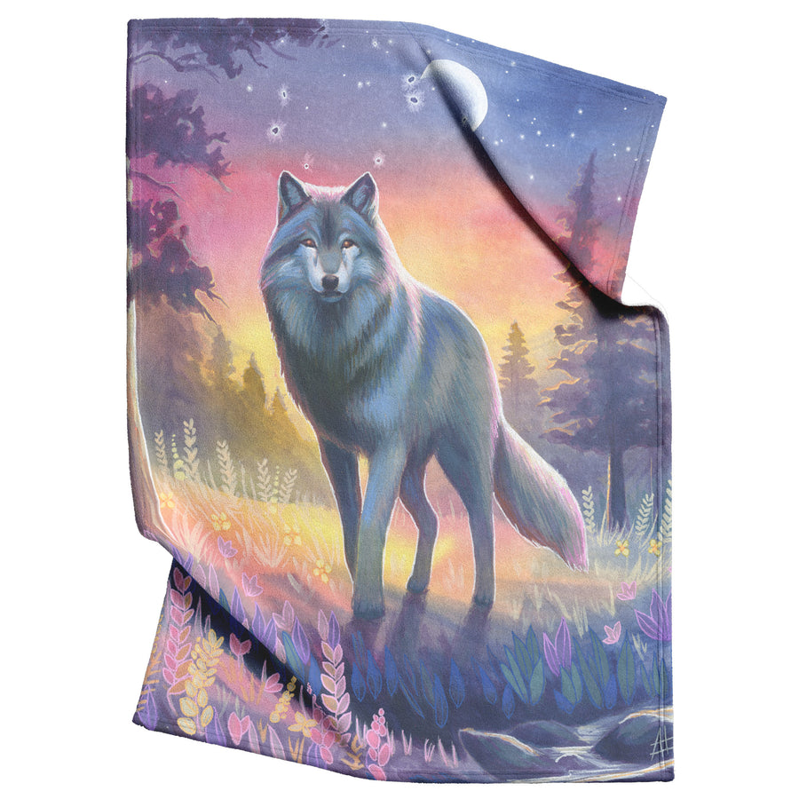A Wolf Blanket featuring a design of a wolf standing in a twilight forest under a starry sky with a crescent moon.