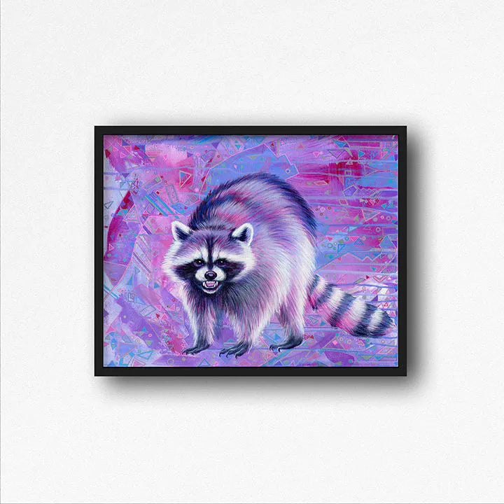 Colorful artwork of a raccoon against a vibrant pink and purple abstract background, encased in a black frame on a white wall.